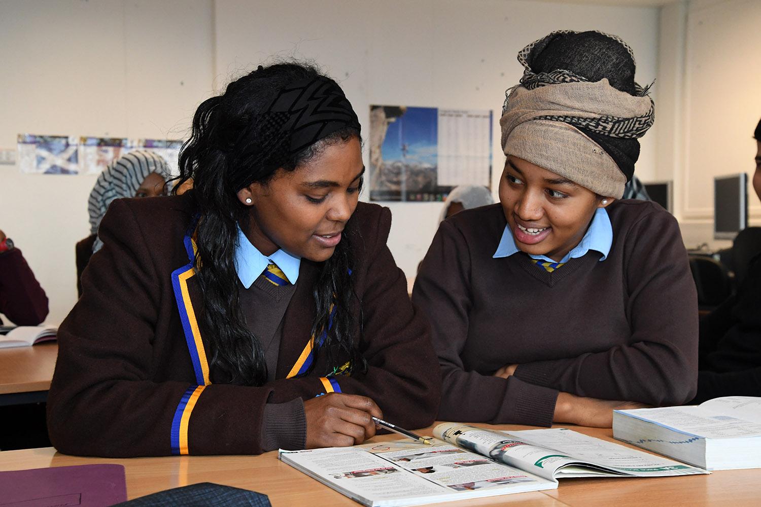 2 students looking at workbook